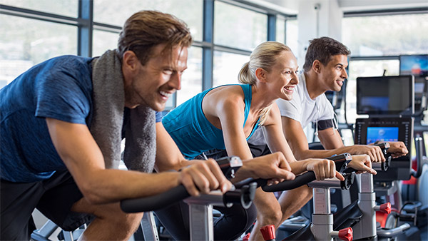 Zwei Männer und eine Frau beim Spinning im Fitnessstudio. Zwei Männer und eine Frau beim Spinning im Fitnessstudio.