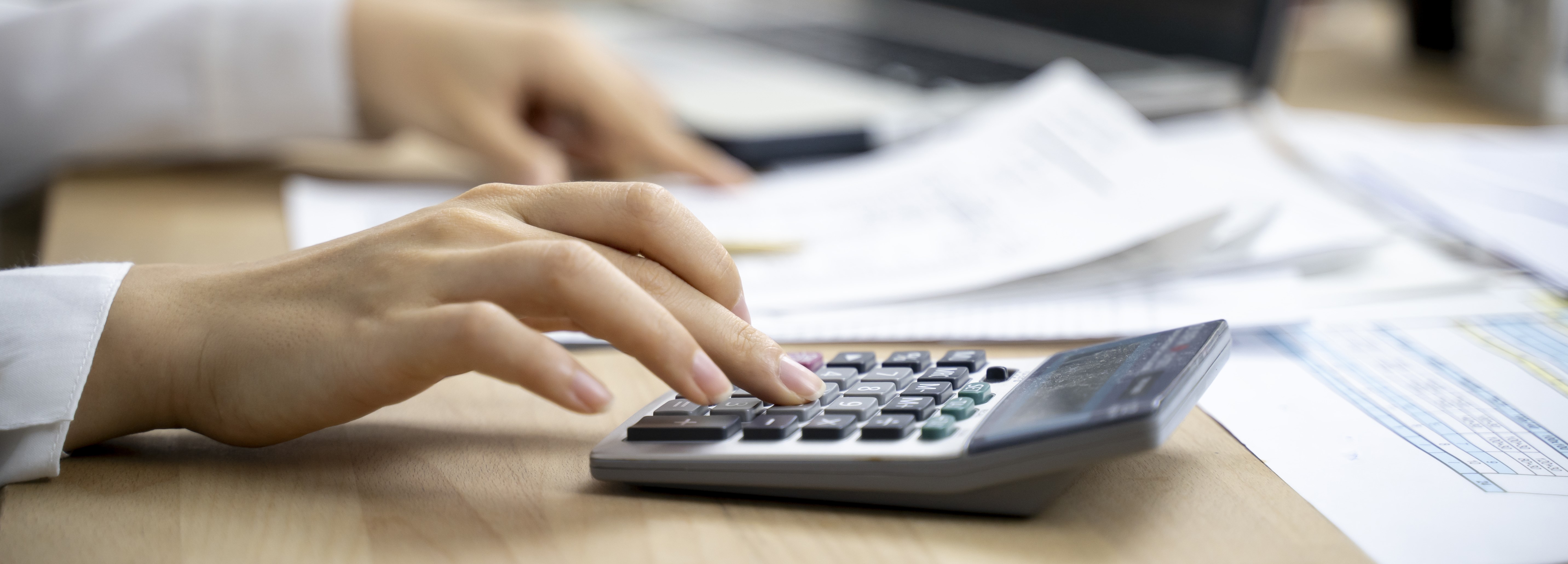 Hand tippt auf Taschenrechner Hand tippt auf Taschenrechner