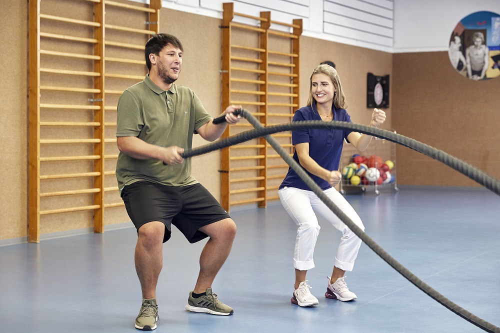 Ein Patient bei der Physiotherapie in der Sporthalle.