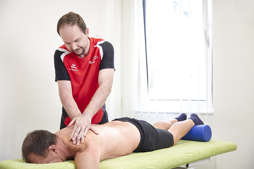 Ein Physiotherapeut massiert einen Patienten. Ein Physiotherapeut massiert einen Patienten.