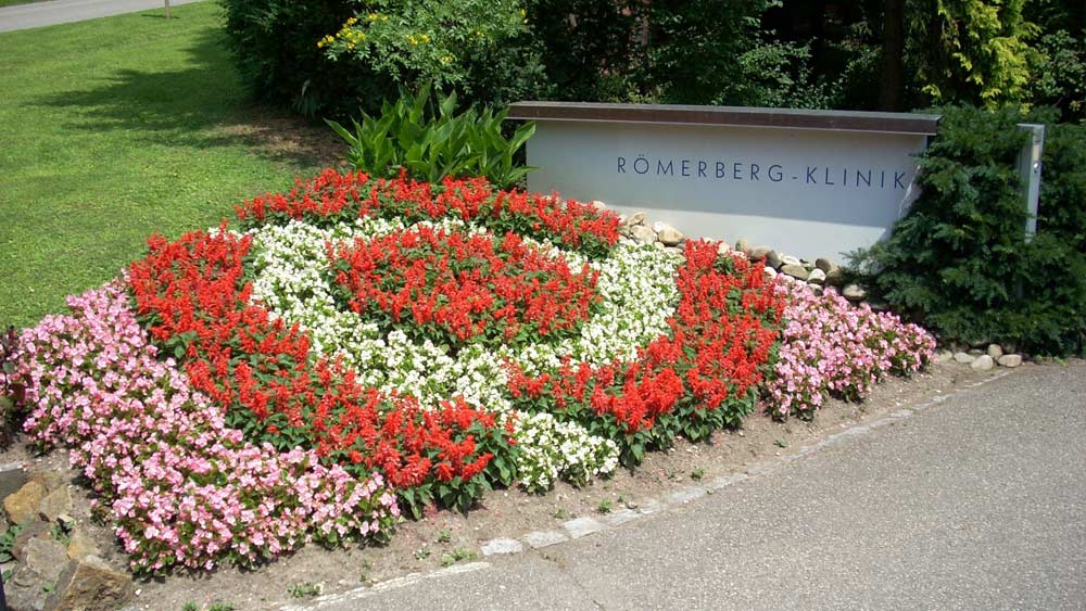 Das Knappschaft-Bahn-See-Logo als Blumenbeet am Eingangsbereich der Römerberg-Klinik in Badenweiler.