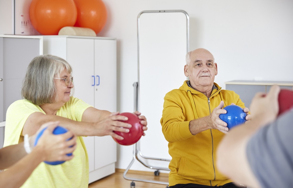 Patientin bei der Physiotherapie wird durch eine Therapeutin unterstützt. Patientin bei der Physiotherapie wird durch eine Therapeutin unterstützt.