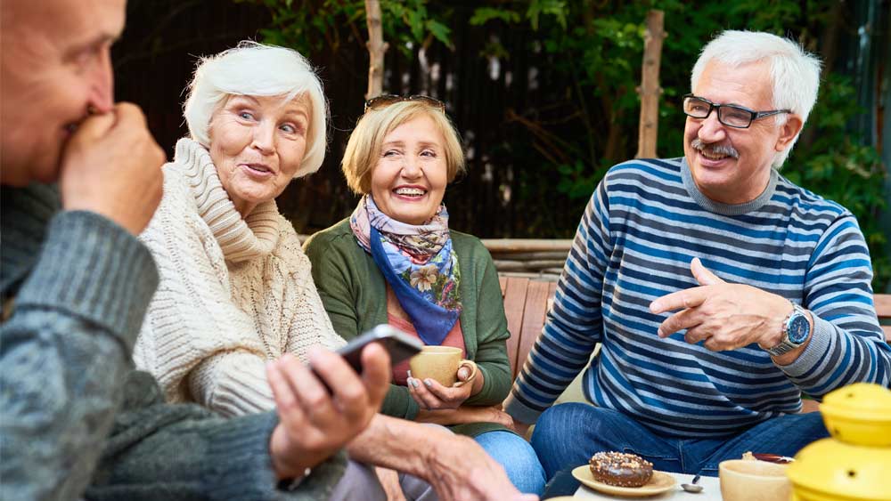 Vier ältere Personen sitzen zusammen. Vier ältere Personen sitzen zusammen.