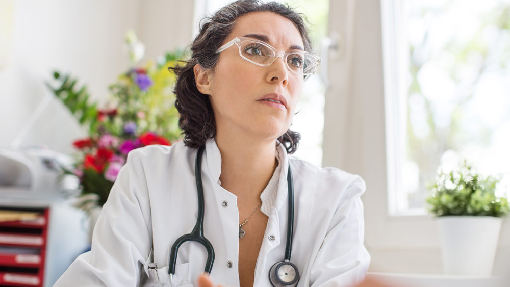 Eine Ärztin sitzt am Schreibtisch. Eine Ärztin sitzt am Schreibtisch.