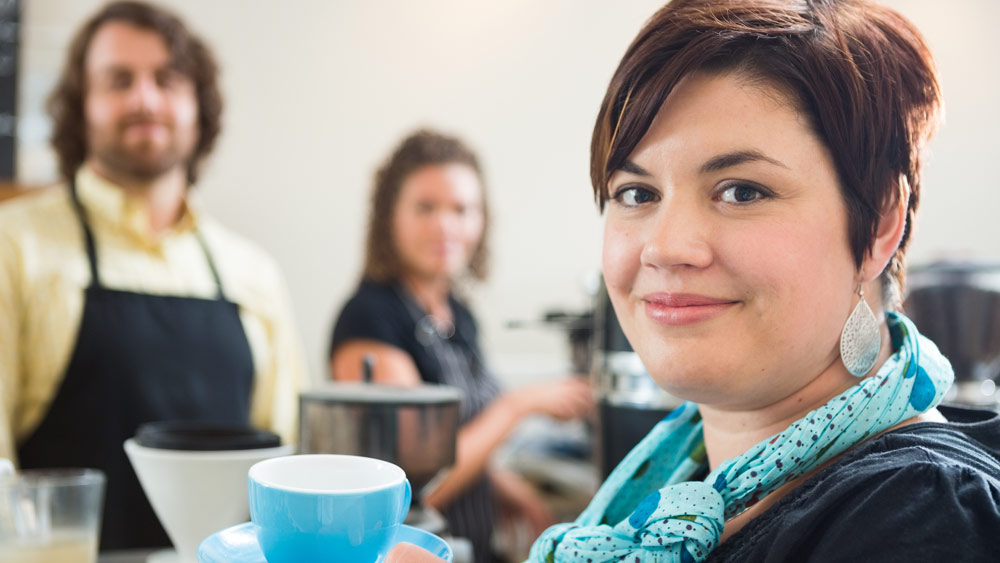 Eine Frau hält eine Kaffeetasse in der Hand. Eine Frau hält eine Kaffeetasse in der Hand.