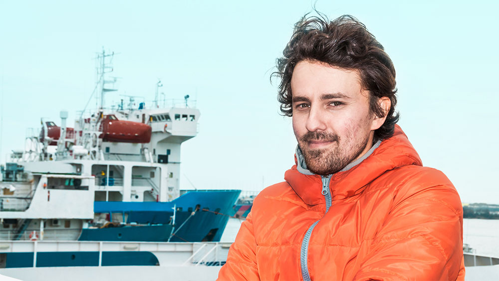 A man in front of a ship